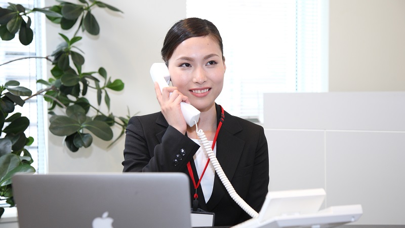 職場で電話に出る女性